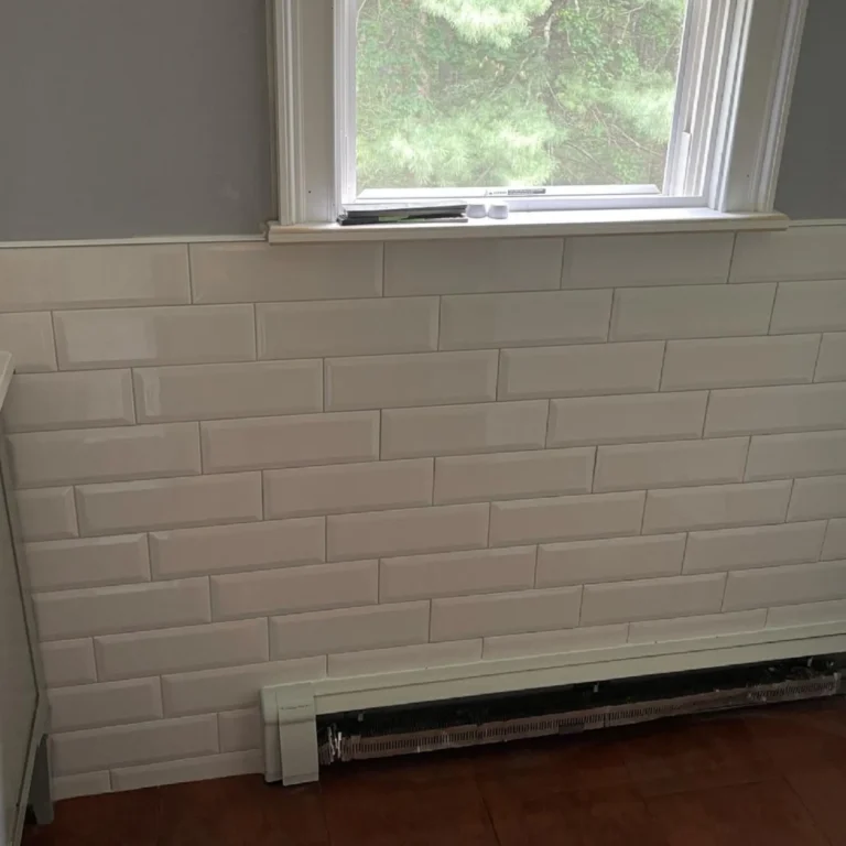White rectangular tile in a brick pattern in a wall with an AC.