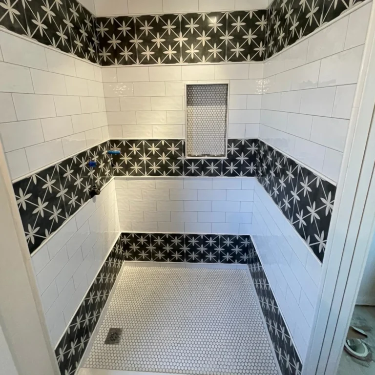 White rectangular tiles and black flower stripes shower.