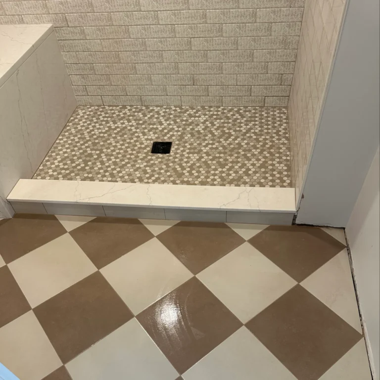 Bathroom floor with brown and beje chess pattern. Shower with stone tiles in the wall.