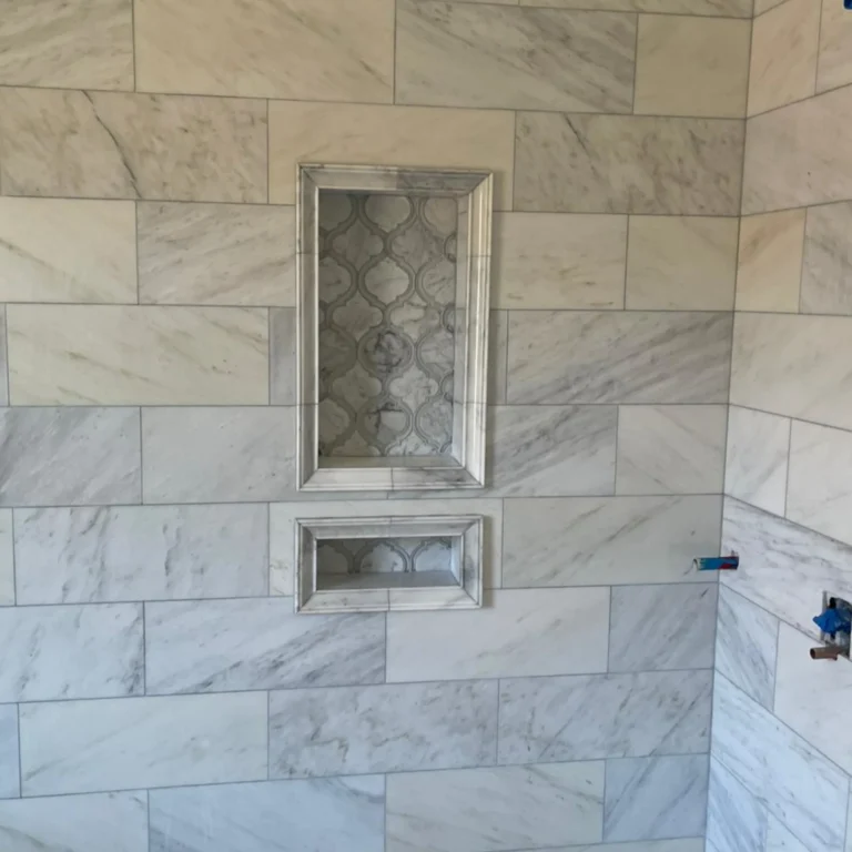 Fancy vintage stone tile installation in a shower with a fancy niche.