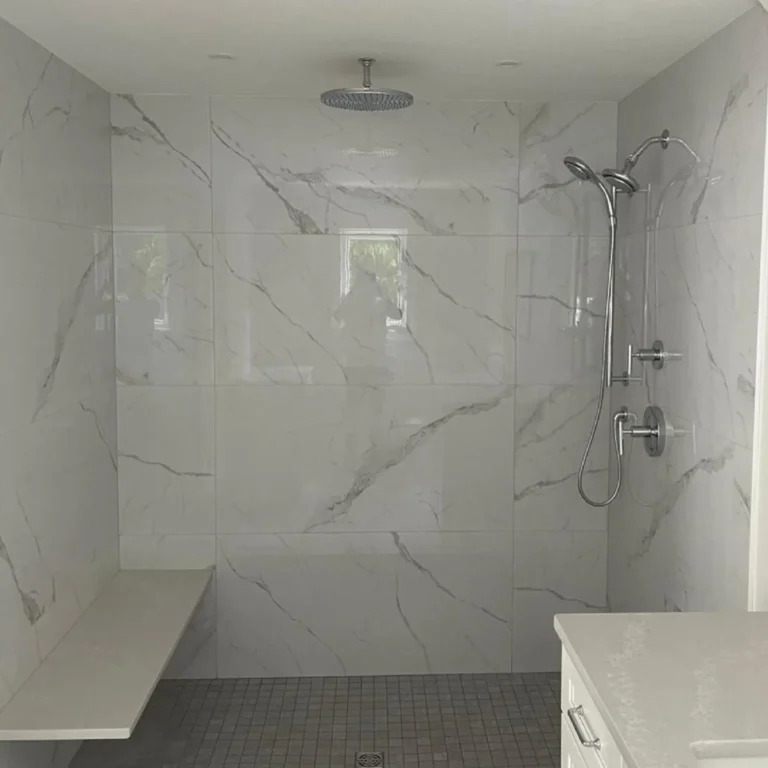 Glossy large white stone tile in a shower.