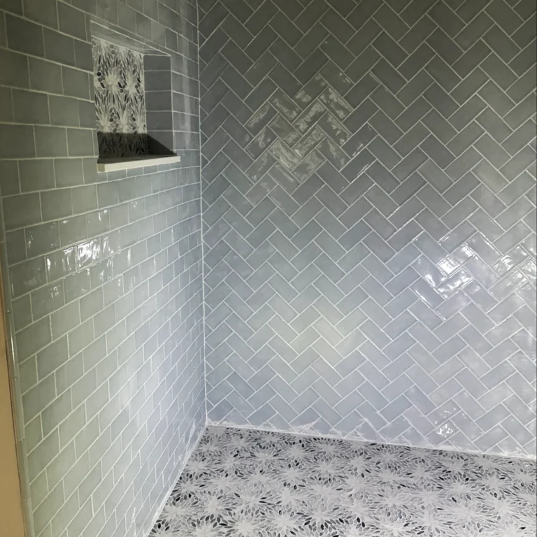 Herringbone pattern tile and brick pattern tile in a shower.