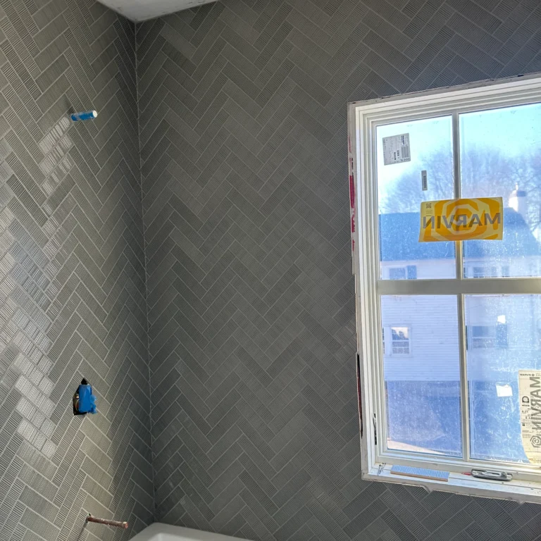 Shower tiles in a herringbone pattern.