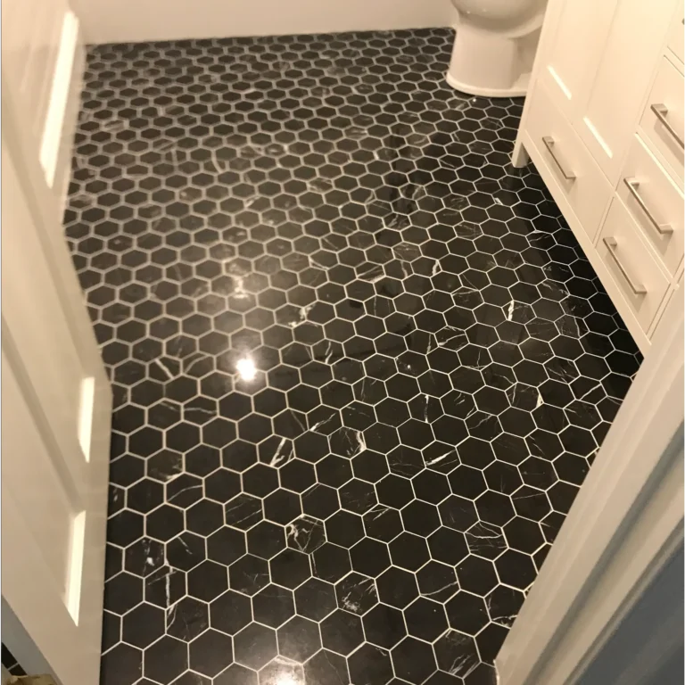 Small hexagonal black stone tiles in a bathroom floor.
