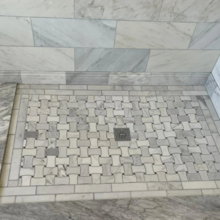Fancy shower with a mosaic floor and brick pattern in the wall.