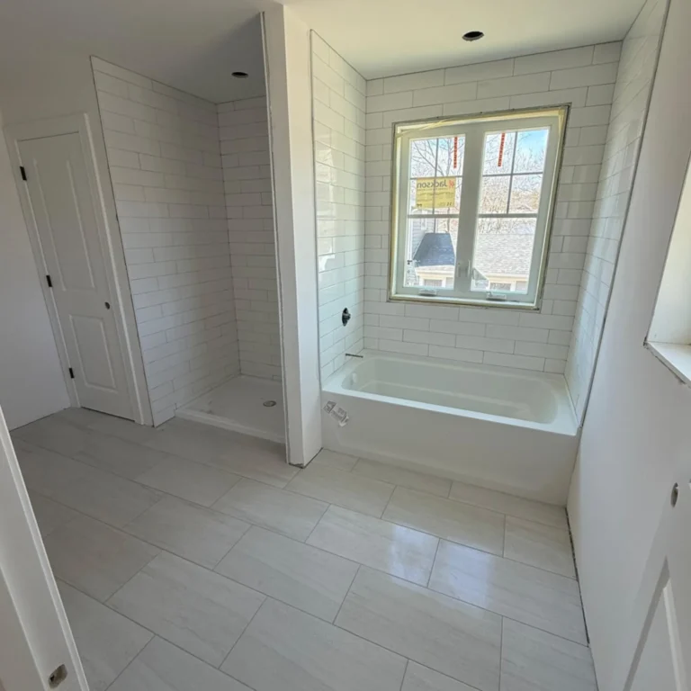 Bathroom with light color tiles with a brick pattern.