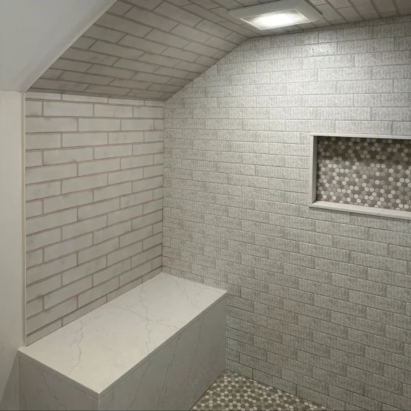 Shower with bevel and rectangular tiles in a brick patterns.